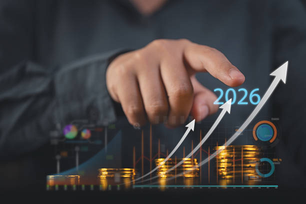 istock Hand pointing at 2026 holographic financial growth chart with stacked coins representing future investment profit and economic success in business innovation 2245661495