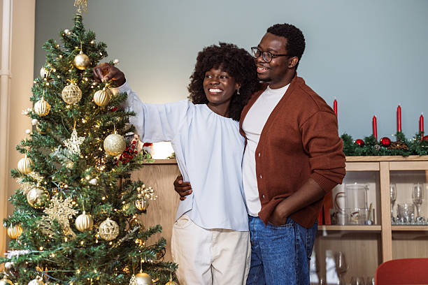 istock African American couple decorating a Christmas tree at home 2245665896