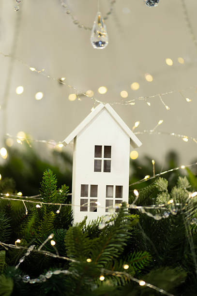 istock White decorative house with fairy lights and fir branches 2245670287
