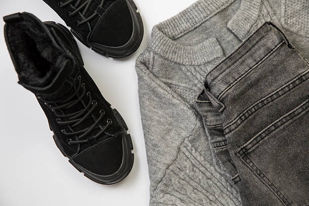 A harmonious combination of black boots, gray jeans, and a sweater, perfect for cold weather