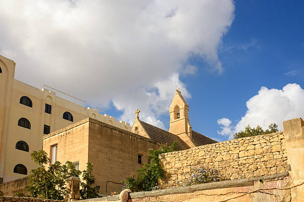 istock Historic Stone Church and Mediterranean Architecture under a Blue Sky 2245671463