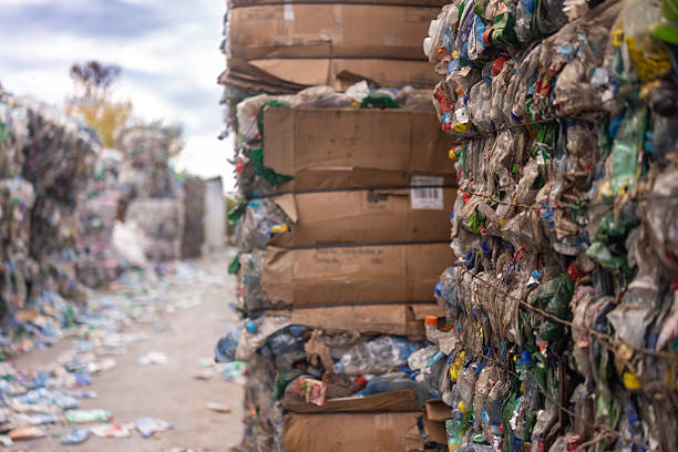 Large bales of compressed plastic and cardboard waste, at a recycling facility or a waste management center