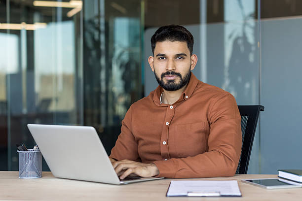istock Young indian businessman working on laptop in modern office 2245673859