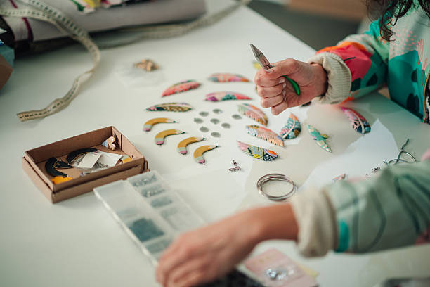 Woman making handmade gemstone jewelry, home workshop. Woman artisan creates jewelry. Art, hobby, handcraft concept