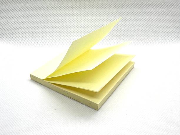 istock Yellow sticky pad with multiple sheets opened and fanned out on a white textured background for creative or office use in presentations and note-taking 2245674568