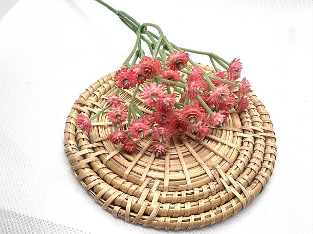istock Stylish round rattan mat featuring vibrant pink flowers, perfect for home decor, table setting, or rustic kitchen accents in natural light setting 2245676436