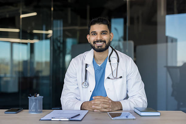 istock Male doctor smiling at desk in office 2245676539