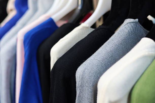 istock Sweaters of different colors hanging in clothing retail store 2245677607