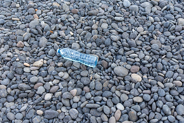 Plastic bottle lying on a pebble beach on chios island, greece, showing environmental pollution concern