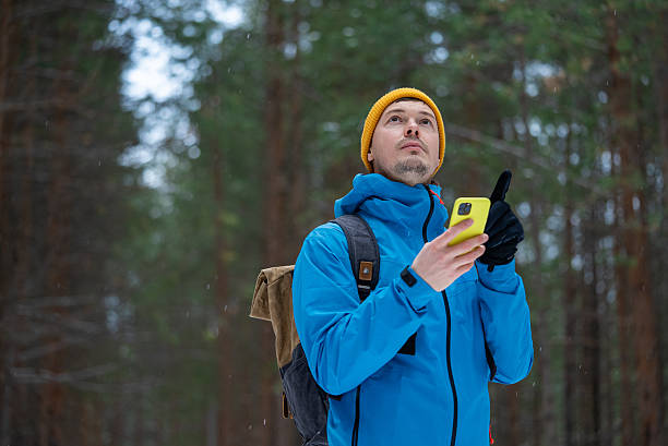istock Adventurer lost in winter forest wilderness, checking smartphone gps navigation for direction, feeling disoriented and searching for path through dense snowy woods 2245678201