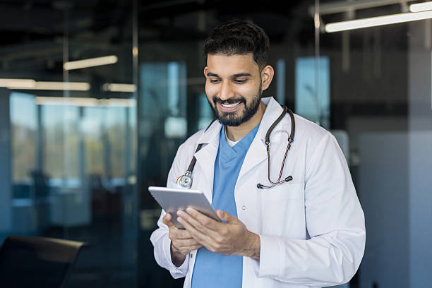 istock Indian doctor smiling and using digital tablet in clinic 2245678549