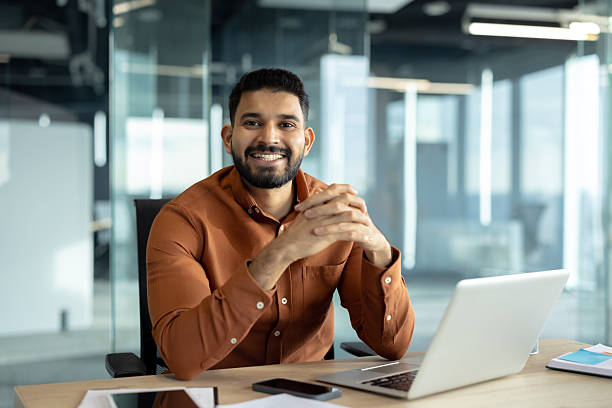 istock Smiling professional sitting at desk in a modern office environment 2245682871