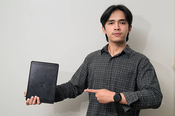 istock Portrait of handsome Young Asian Thai man using digital tablet computer against white background 2245684922