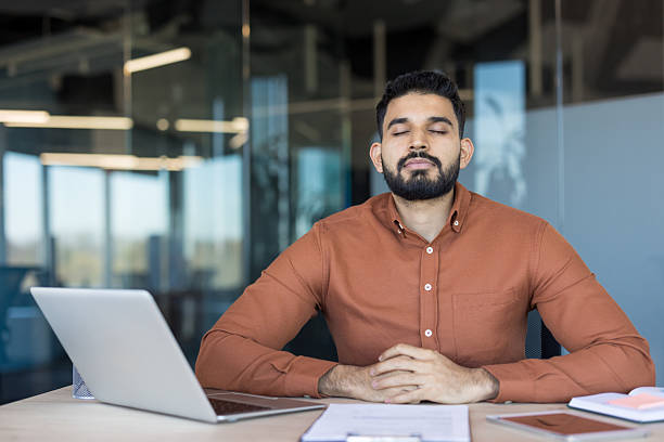 istock Businessman meditating at desk reducing work stress 2245687317