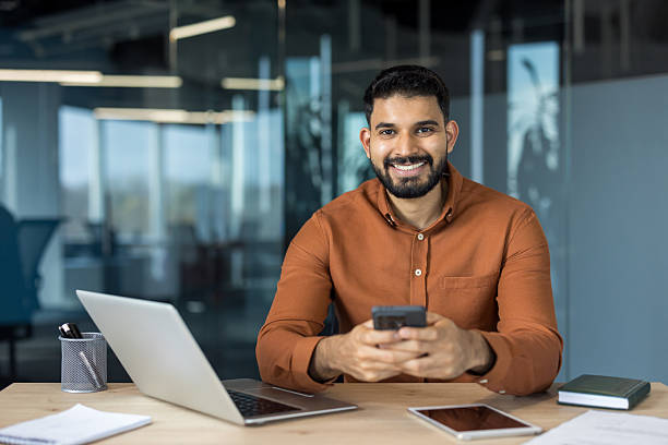 istock Indian businessman using smartphone at office desk 2245687383