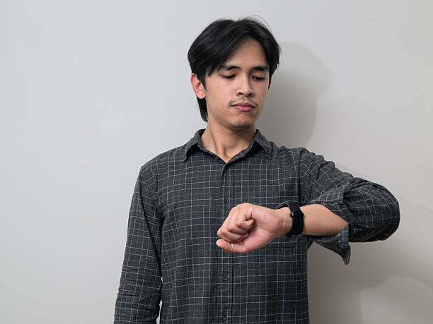 istock Portrait of handsome Young Asian Thai man using smartwatch against white background 2245688530