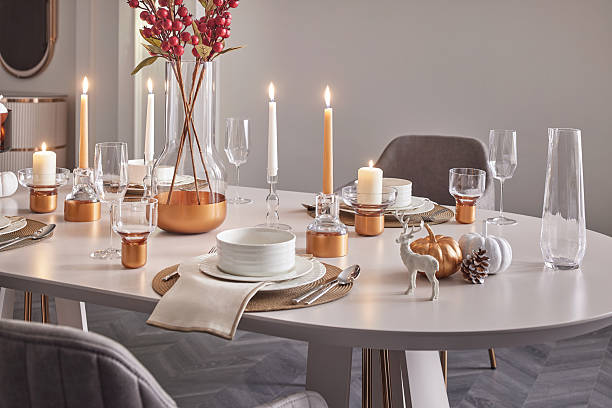 istock Elegant Christmas table setting close-up. Festive dinnerware, gold accents, and lit candles for a holiday celebration. 2245688545