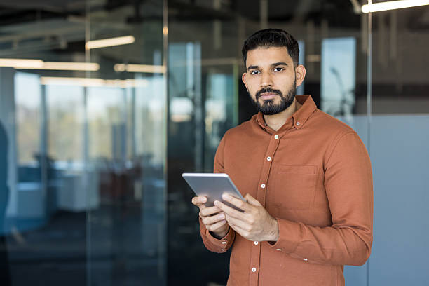 istock Indian businessman holding tablet in modern office 2245688644