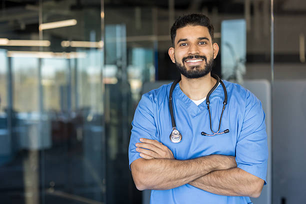 istock Young indian man doctor smiling, wearing scrubs 2245690693