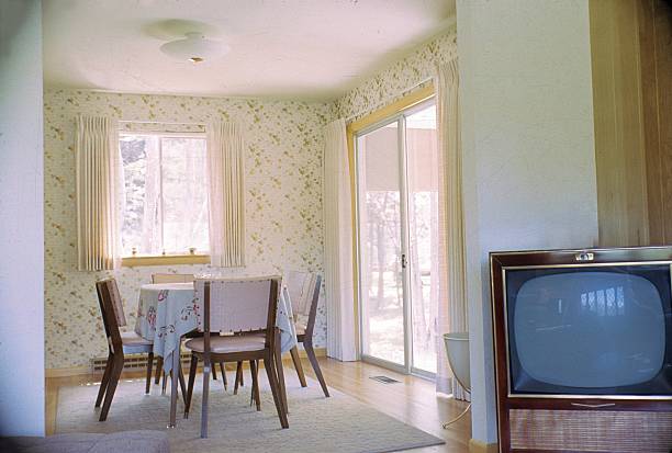 Illinois, USA, 1963. Dining table with chairs and a television set in an American bungalow.