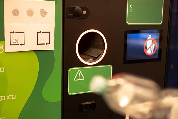 istock Man hand puts plastic bottle to the Recycling machine. Shoppers return their bottles and cans. 2245695298