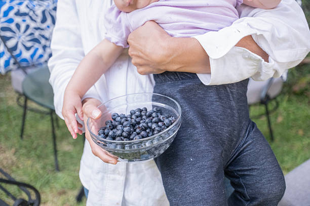 baby eating healthily with blueberries