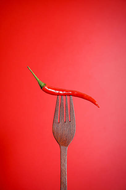 istock Fresh red chilli on wooden fork with red background 2245696712
