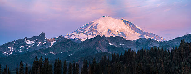 istock Mount Rainier glows at sunset above evergreen forest. 2245703156