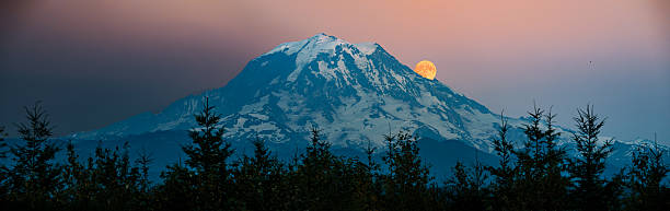 Mountain Moon Majesty is on full display at Mount Rainier National Park in Washington, United States. Established in 1899, the park preserves the natural and cultural history of this iconic Washington landmark.