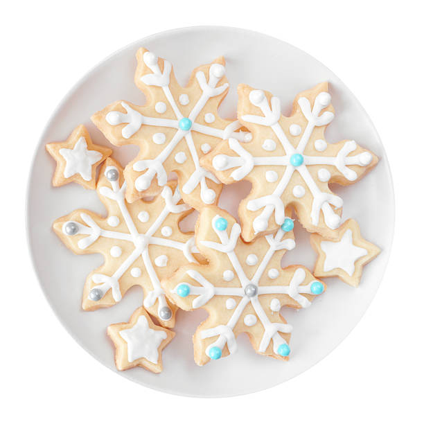 Christmas snowflake cookies. Top down view plate isolated on a white background.