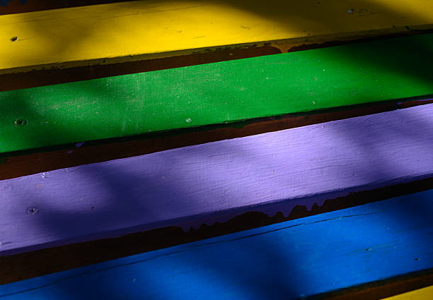 Close-up of colorful wooden bench planks. Painted wood surface with aged texture, ideal as a natural background or design texture.