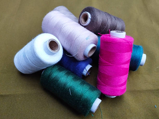 istock A colorful collection of sewing thread spools scattered on an olive-green fabric 2245717533