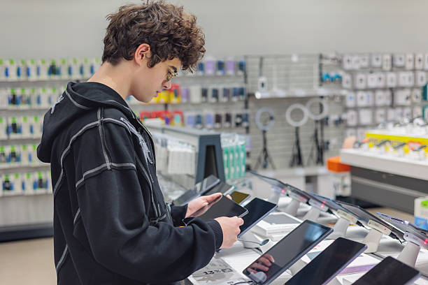 istock Teenager Choosing a Tablet in Electronics Store – Young Customer Testing Digital Devices, Tech Shopping and Consumer Behavior 2245717773