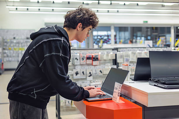 istock Teenager Choosing a Laptop in Electronics Store – Young Customer Testing Computers, Tech Shopping, Retail Consumer Behavior, Gadget Choice 2245718807