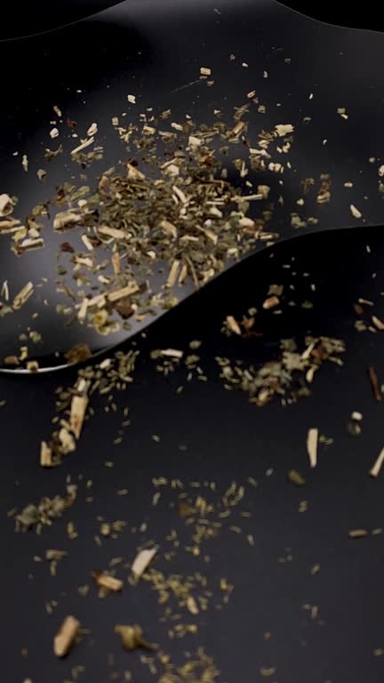 Herbal tea blend with chamomile, melissa, and hibiscus on black background