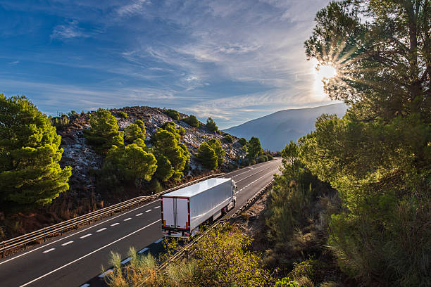 istock Refrigerated truck driving along a mountain road surrounded by forest 2245732464