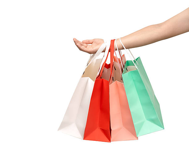 istock A person's hand holding a paper shopping bag with handles on a clean white background. Studio shot with ample copy space for text, logos, or branding. Isolated on white, cut out. 2245738301