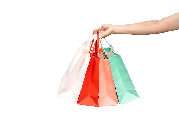 istock A person's hand holding a paper shopping bag with handles on a clean white background. Studio shot with ample copy space for text, logos, or branding. Isolated on white, cut out. 2245738312