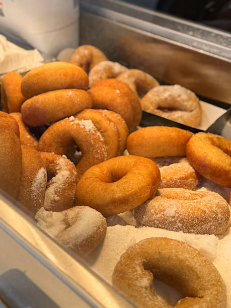 istock Image of freshly fried ring doughnuts covered in caster sugar / sweet bakery donuts, cakes displayed, golden texture, classic homemade appeal 2245740232