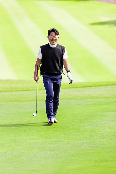 A middle-aged Japanese man enjoying golf