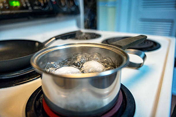 istock Two Eggs Cooking in Boiling Water on Electric Stove 2245744898