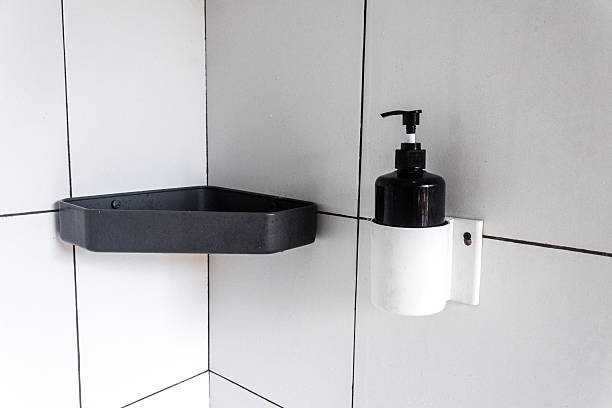 istock A wall-mounted black hand soap dispenser on a white ceramic wall 2245747466