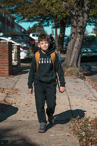 istock 10-year-old boy with backpack walking home from American school, portrait 2245755700