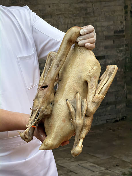 A Cantonese chef holding a poached goose (close-up)
