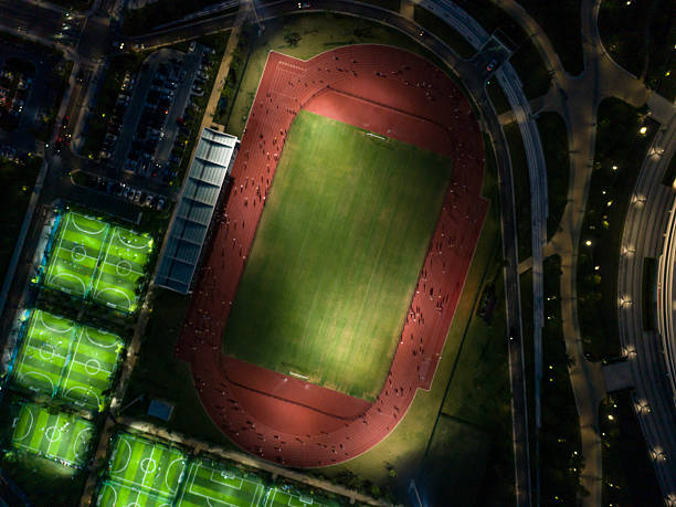 istock Aerial view of a well-lit sports complex at night with various fields bustling with activity in an urban setting 2245758292