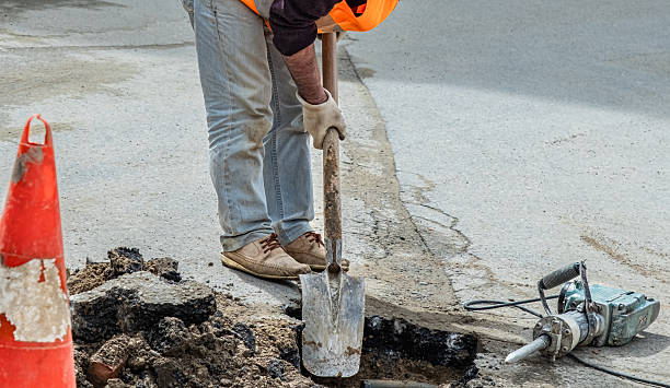 istock A plumber working on the street road opening asphalt using special equipment. 2245771940