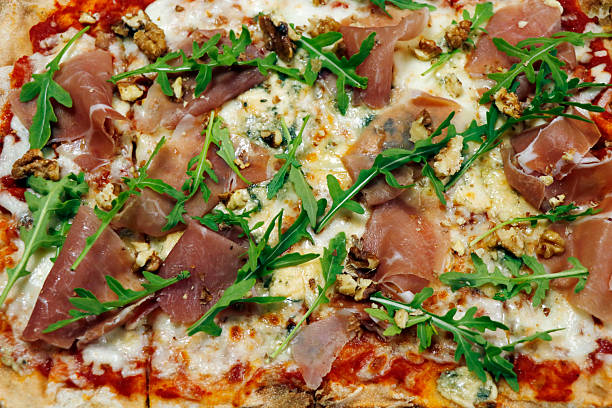 istock authentic italian pizza with melted cheese parma ham and rocca leaves in close up 2245777928