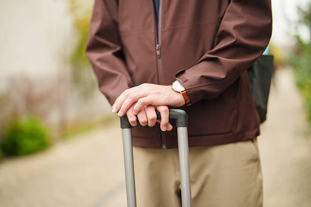 istock Traveler holding suitcase handle outdoors 2245778727