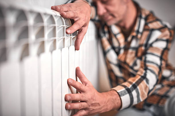 istock Man heating on a chilly winter day, energy and gas crisis, cold room, heating problems. 2245783588