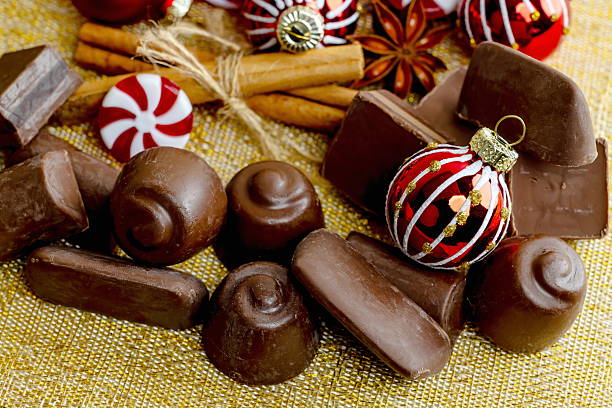 istock Chocolates with Christmas decorations on a golden background 2245791943